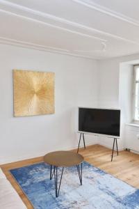 a living room with a tv and a table at The R Apartment Cholfirst in Schaffhausen