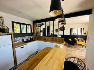 a kitchen with a wooden table and a living room at Maison Ostréa terrasse sur l'eau in Gujan-Mestras