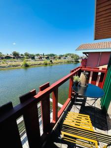 a table and chairs sitting on a balcony next to a river at Maison Ostréa terrasse sur l'eau in Gujan-Mestras
