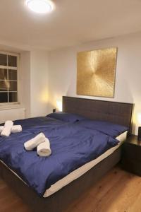 a bedroom with a blue bed with two towels on it at The R Apartment Cholfirst in Schaffhausen