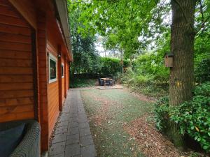 een loopbrug naast een boom naast een huis bij Chalet Ermelo in Ermelo