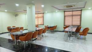 uma sala de jantar com mesas, cadeiras e janelas em HOTEL AMAR PALACE BHARATPUR em Bharatpur