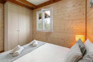 um quarto com uma cama branca numa parede de madeira em Quinta dos Castanheiros em Usseira