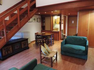 ein Wohnzimmer mit einer Treppe, einem Sofa und einem Tisch in der Unterkunft Appartamento per 6 nel Residence La Ginestra in Pescasseroli