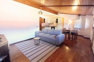 sala de estar con sofá azul y cocina en Appartamento in centro con vista lago a 5 minuti da Menaggio, en Acquaseria