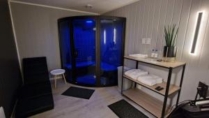 ein Bad mit blauer Dusche in einem Zimmer in der Unterkunft Nord Hus Service AS, Deluxe, Sauna, Jakuzzi in Havøysund
