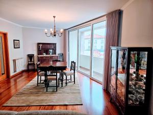 ein Esszimmer mit Tisch und Stühlen und einem Fenster in der Unterkunft Casa da Senra in Vila do Conde