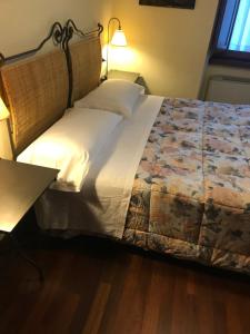 a bedroom with a bed with white sheets and a lamp at RESIDENCE GRAN SASSO in Pietracamela