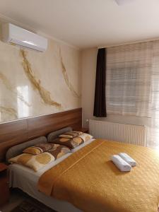 A bed or beds in a room at Boglárka Vendégház