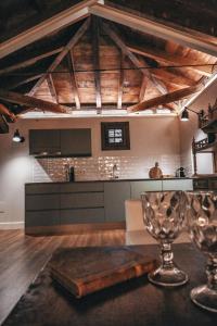 a kitchen with wooden ceilings and a table with a wine glass at Casa Airosas in Toledo