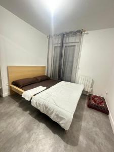 um quarto com uma cama e uma janela em Sweat Home em Sevran