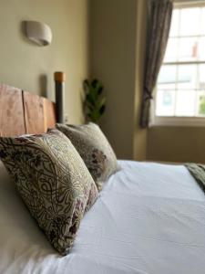 a bed with two pillows on it with a window at The Roost in Cullompton