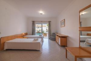 a hotel room with two beds and a mirror at Aldeamento Turistico Aldeia da Galé in Albufeira +101 photos