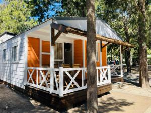 una casa pequeña con un exterior naranja y blanco en Camping Paloma, en Tarifa