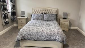 een slaapkamer met een groot bed met 2 nachtkastjes bij Johnny Murphy's Guest Rooms in Meigh
