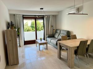 a living room with a table and a couch at Perseo by Albir Proper Properties in Albir