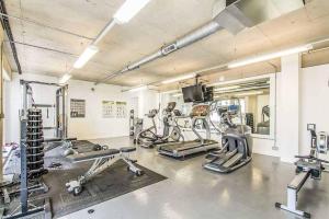 a gym with several treadmills and cardio machines at Close To Leeds City, Spacious, Sleeps 4, in Beeston Hill
