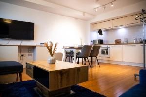 a living room with a table and a kitchen at Close To Leeds City, Spacious, Sleeps 4, in Beeston Hill