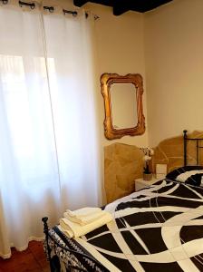 Il Rifugio di Piazza dell' Oca في رونسيجليونى: غرفة نوم مع سرير ومرآة على الحائط
