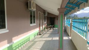 an empty porch of a house with a blue railing at Teratak Cikgu Homestay in Pasir Puteh