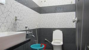 a bathroom with a white toilet and a sink at Mahabala Valley Guest House in Gokarna