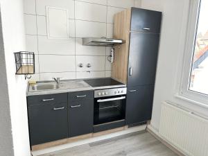 cocina con nevera negra y fregadero en Cozy Room in a Sharing Apartment WG in the black forest en Villingen-Schwenningen