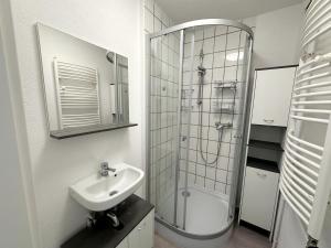 een witte badkamer met een wastafel en een douche bij Cozy Room in a Sharing Apartment WG in the black forest in Villingen-Schwenningen