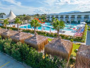 an overhead view of a resort pool with straw umbrellas at Assos Barbarossa Special Class Hotel in Behramkale