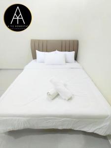 ein großes weißes Bett mit einem Handtuch drauf in der Unterkunft A YIE HOMESTAY in Kuantan