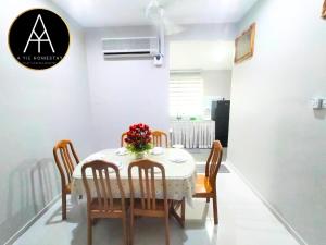 a dining room with a table with chairs and flowers on it at A YIE HOMESTAY in Kuantan