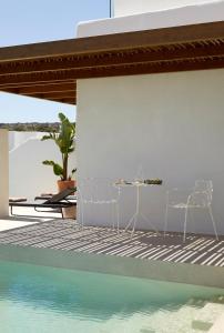 two chairs and a table next to a swimming pool at PAROCKS Luxury Hotel & Spa in Ambelas