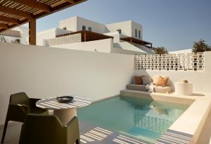 a pool with a table and chairs next to a house at PAROCKS Luxury Hotel & Spa in Ambelas