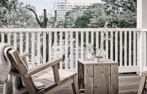 a wooden chair and a table on a balcony at The Cozy Hotel & Lofts Timmendorfer Strand in Timmendorfer Strand