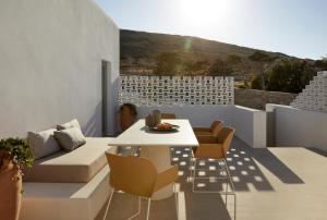a patio with a table and chairs on a balcony at PAROCKS Luxury Hotel & Spa in Ambelas