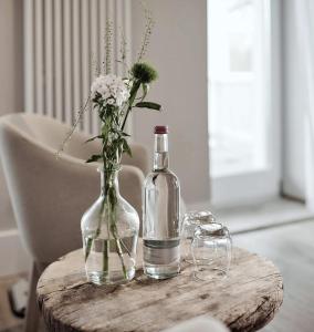 a bottle of wine and a vase of flowers on a table at The Cozy Hotel & Lofts Timmendorfer Strand in Timmendorfer Strand
