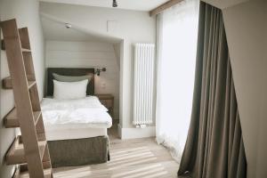 a small bedroom with a bed and a window at The Cozy Hotel & Lofts Timmendorfer Strand in Timmendorfer Strand