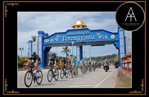 a group of people riding bikes down a road at A YIE HOMESTAY in Kuantan