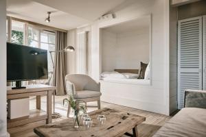a living room with a tv and a couch and a table at The Cozy Hotel & Lofts Timmendorfer Strand in Timmendorfer Strand