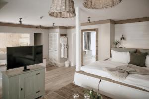 a bedroom with a bed and a flat screen tv at The Cozy Hotel & Lofts Timmendorfer Strand in Timmendorfer Strand