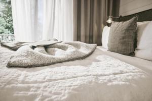 a book laying on top of a white bed at The Cozy Hotel & Lofts Timmendorfer Strand in Timmendorfer Strand