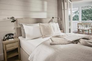 a bed with white sheets and pillows in a bedroom at The Cozy Hotel & Lofts Timmendorfer Strand in Timmendorfer Strand