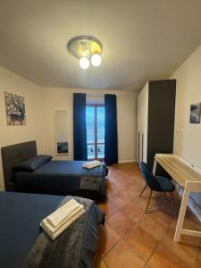 a bedroom with two beds and a table and a chair at Fronte lago nel centro storico “La Casa del Lago” in Trevignano Romano