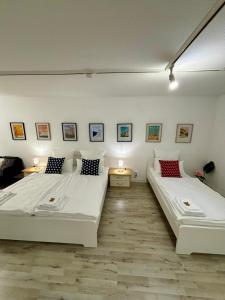 Duas camas num quarto com paredes brancas em Quartier Wenzelnberg work&stay em Langenfeld