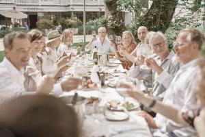 a group of people sitting around a long table at The Cozy Hotel & Lofts Timmendorfer Strand in Timmendorfer Strand