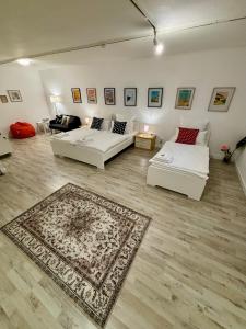 una sala de estar con 2 sofás blancos y una alfombra en Quartier Wenzelnberg work&stay, en Langenfeld