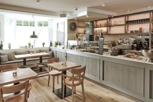 a restaurant with wooden tables and a bar at The Cozy Hotel & Lofts Timmendorfer Strand in Timmendorfer Strand