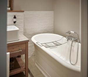 a white bath tub in a bathroom with a sink at The Cozy Hotel & Lofts Timmendorfer Strand in Timmendorfer Strand