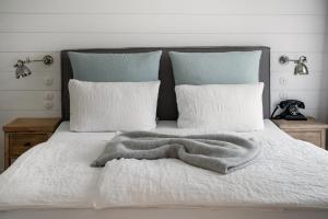 a white bed with a blanket and pillows at The Cozy Hotel & Lofts Timmendorfer Strand in Timmendorfer Strand