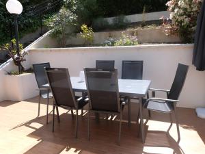 a dining table and chairs on a patio at GASETIENNE Mazet T2 dans domaine avec piscines et tennis in Gassin +5 photos