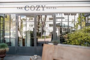 a lobby of a cozy hotel with glass doors at The Cozy Hotel & Lofts Timmendorfer Strand in Timmendorfer Strand